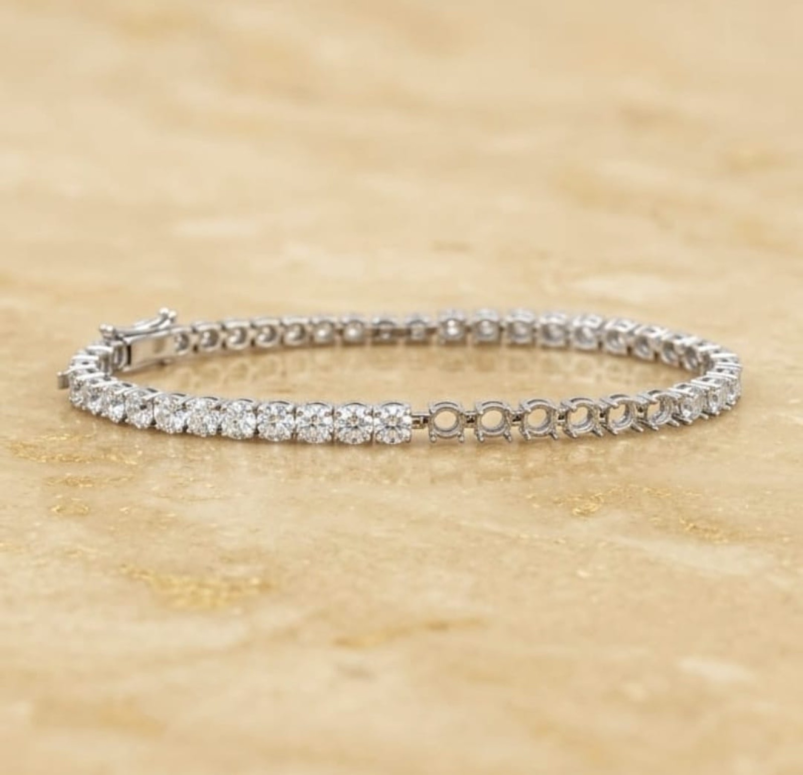 Diamond tennis bracelet in white gold on travertine
